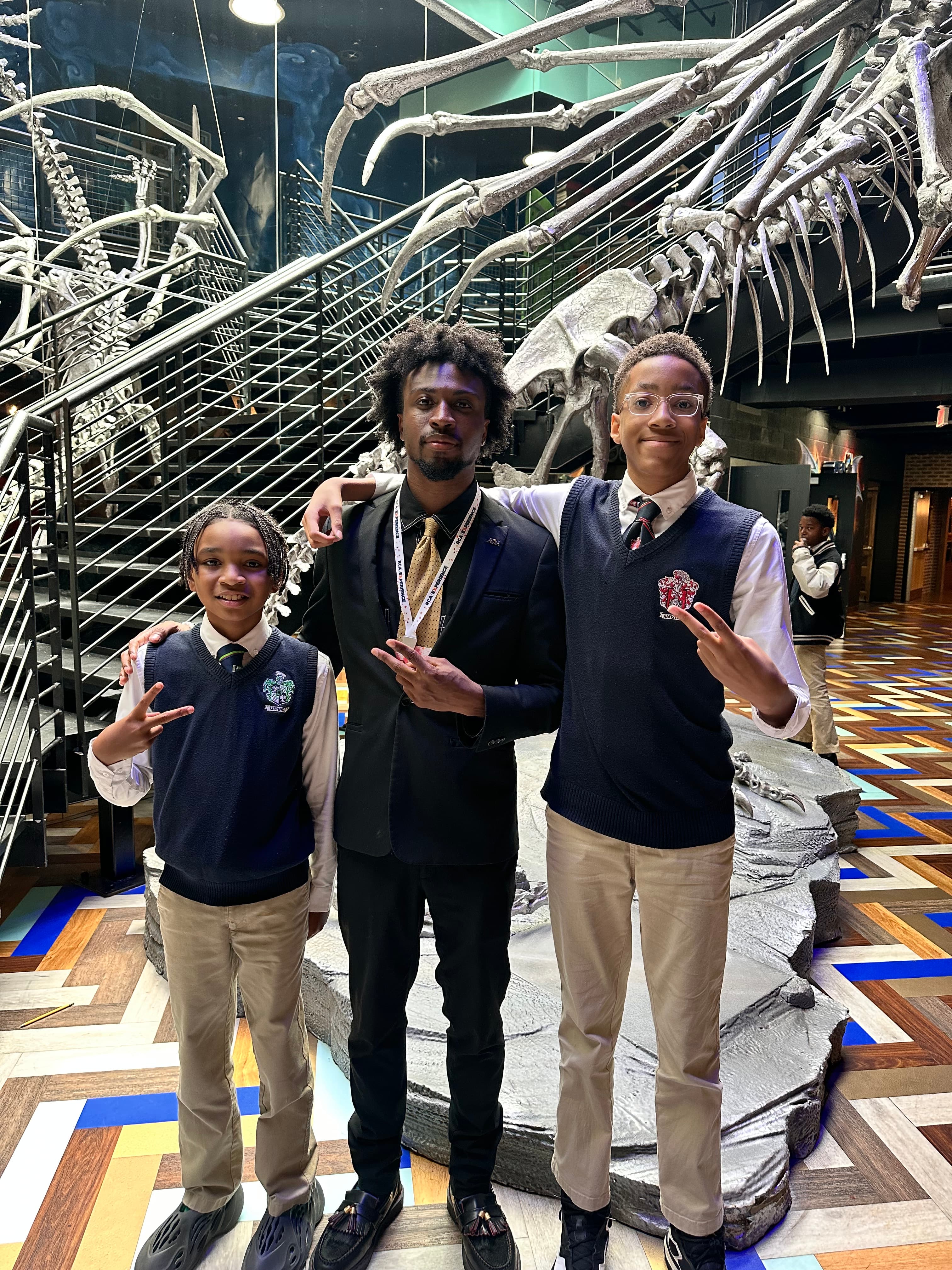 Jordan standing with students during a museum learning trip.